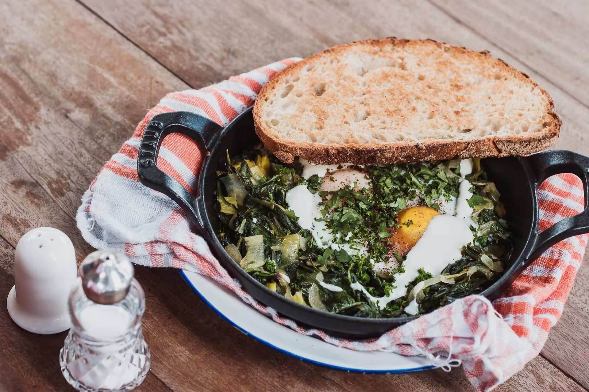 A pan of homemade green shakshuka garnished with herbs