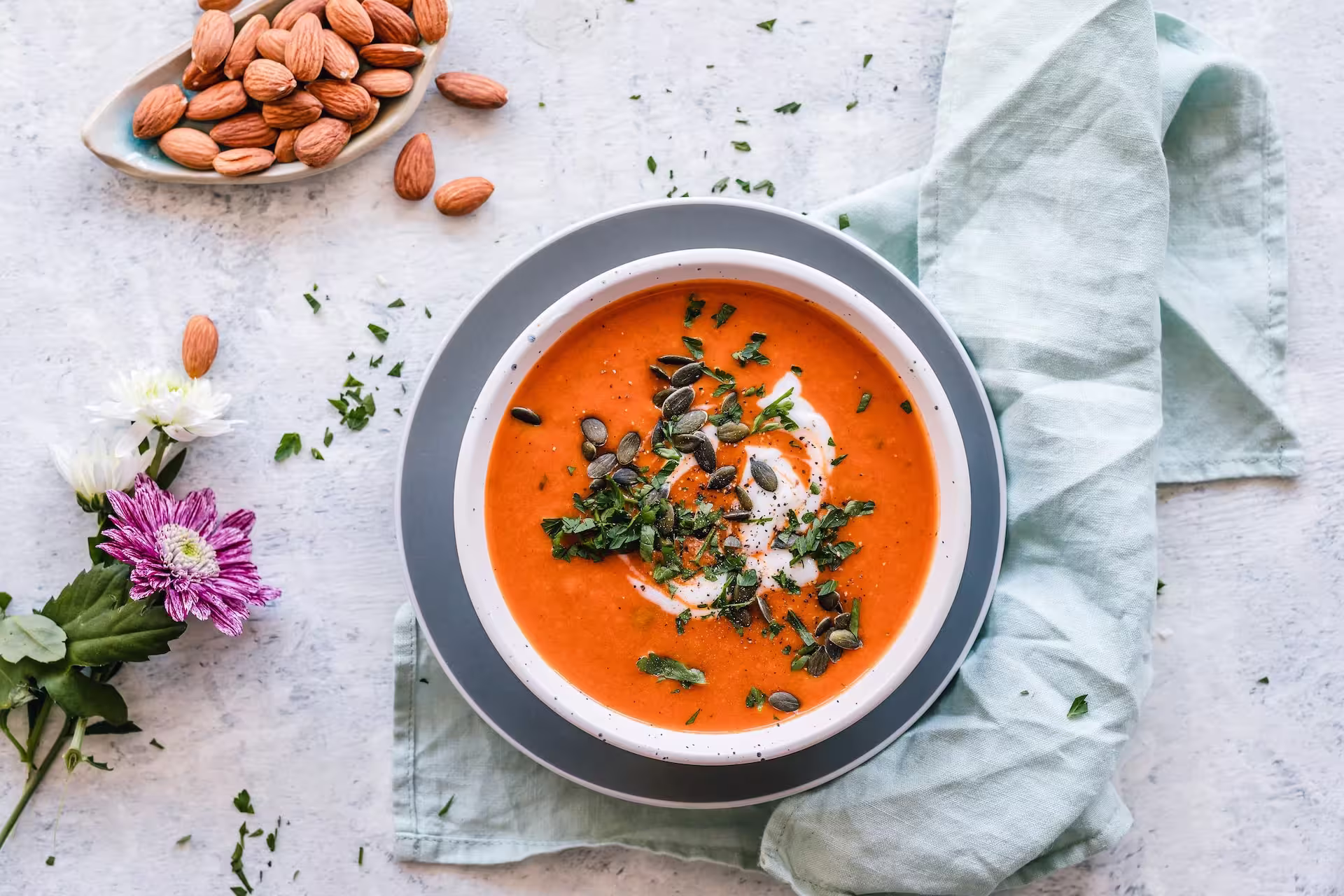 Bowl of homemade creamy pumpkin soup garnished with cream and herbs