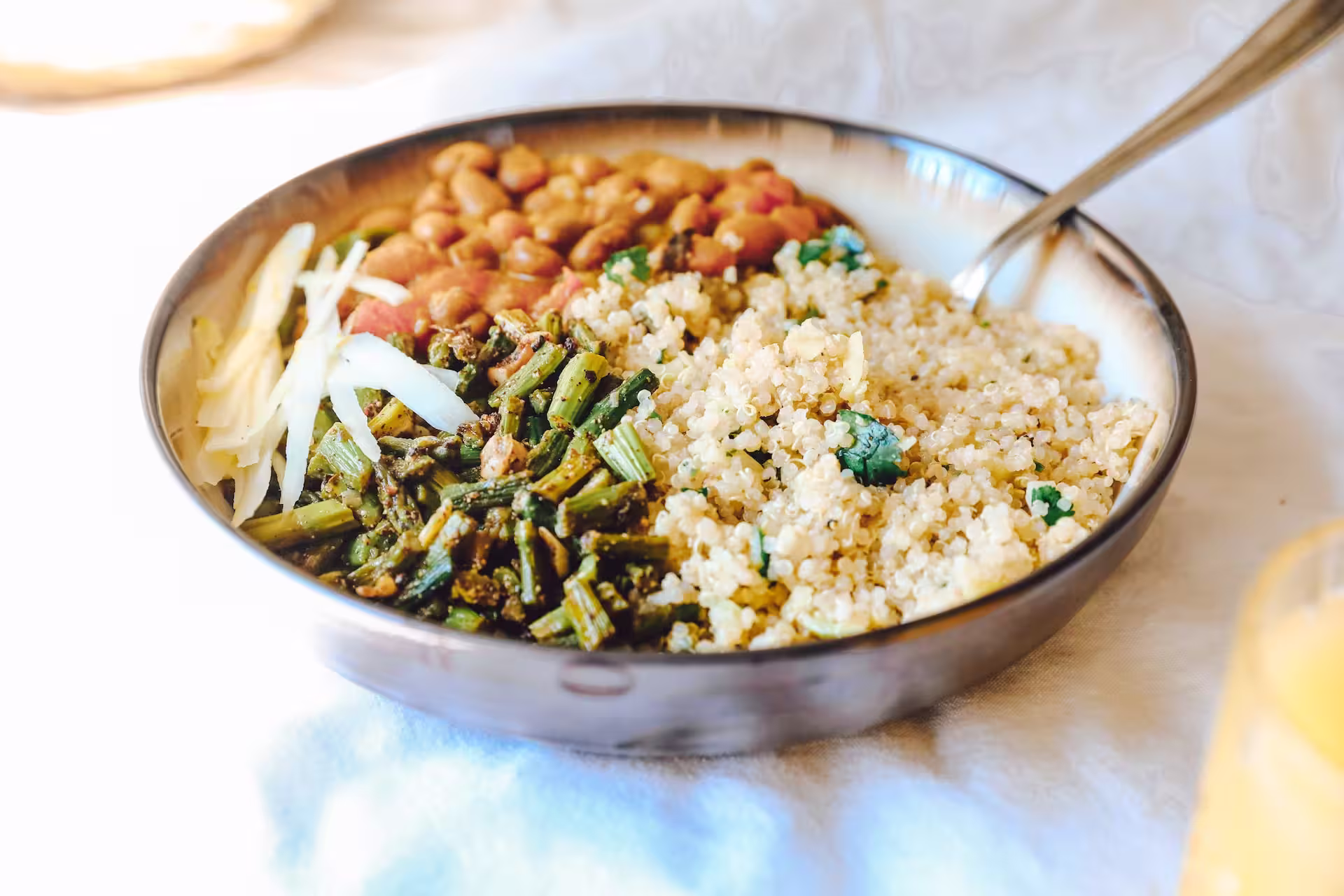 Bowl of quinoa and pinto beans with fresh asparagus