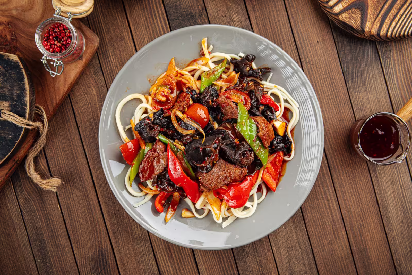 A bowl of Uyghur Guiru Lagman Noodles topped with ear mushrooms and green onions